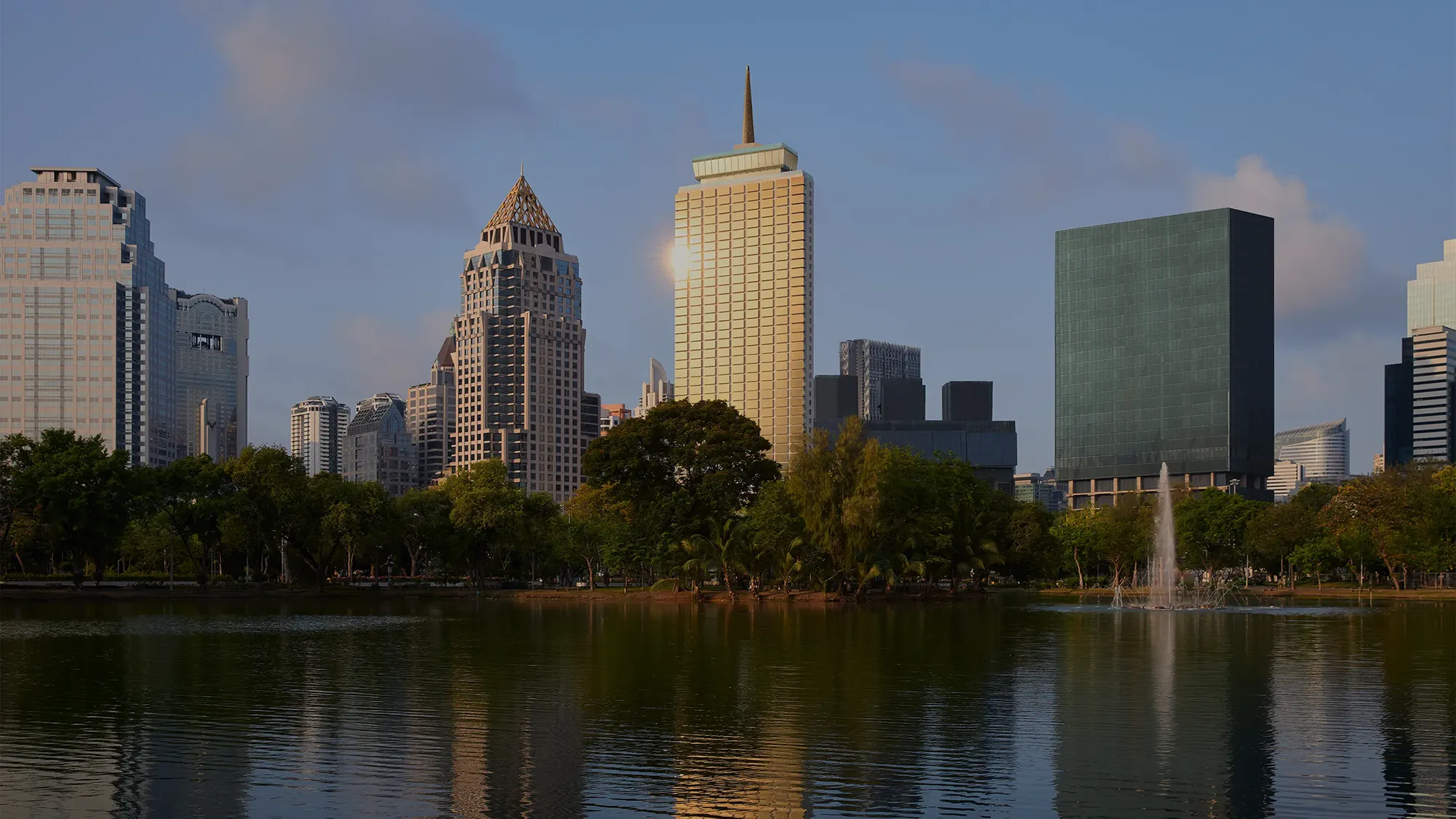 The Bangkok skyline from the perspective of a city park lake reflecting the skyline on the water