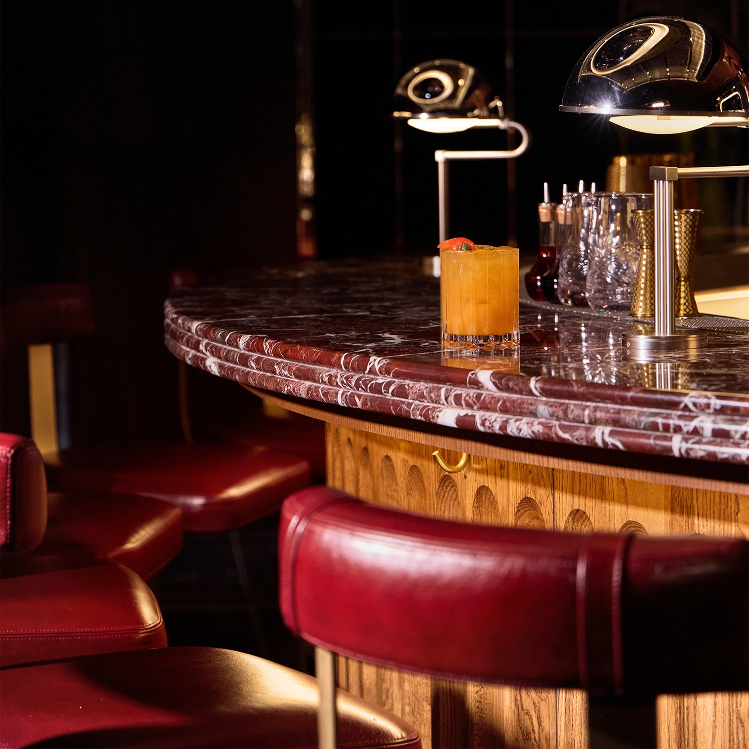 Marble bartop closeup with a leather cladded wooden barstool