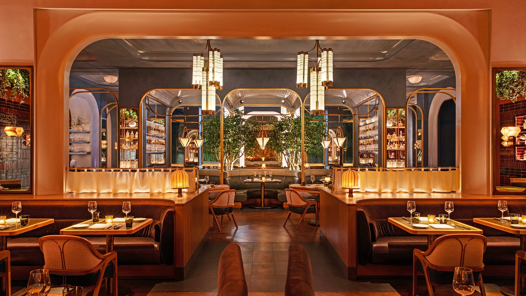 A restaurant main entrance with elegantly designed lighting fixtures and booths for parties to enjoy their meal