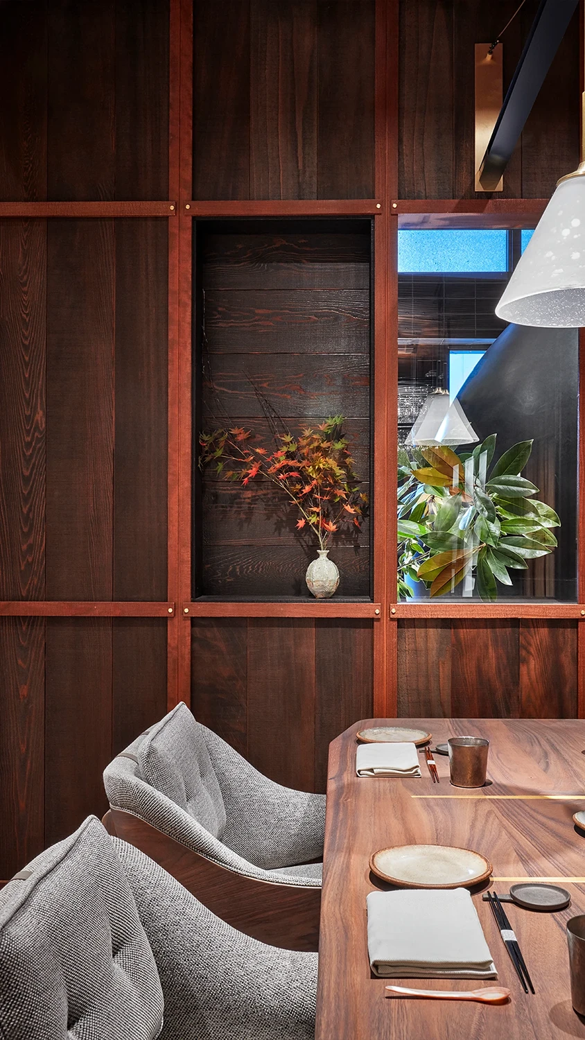 A private wooden dining area set for a private dinner with well designed bespoke chairs