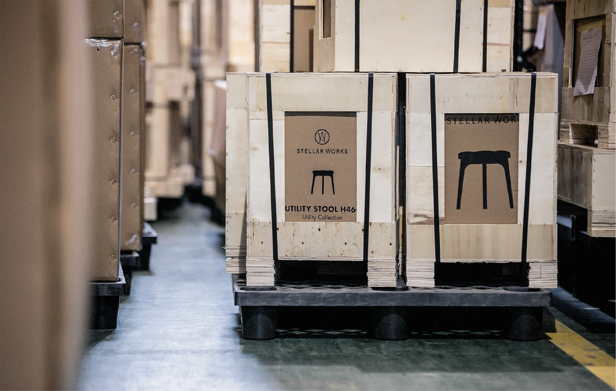A room full of pallets with boxes stacked detailing products inside with  the name and picture