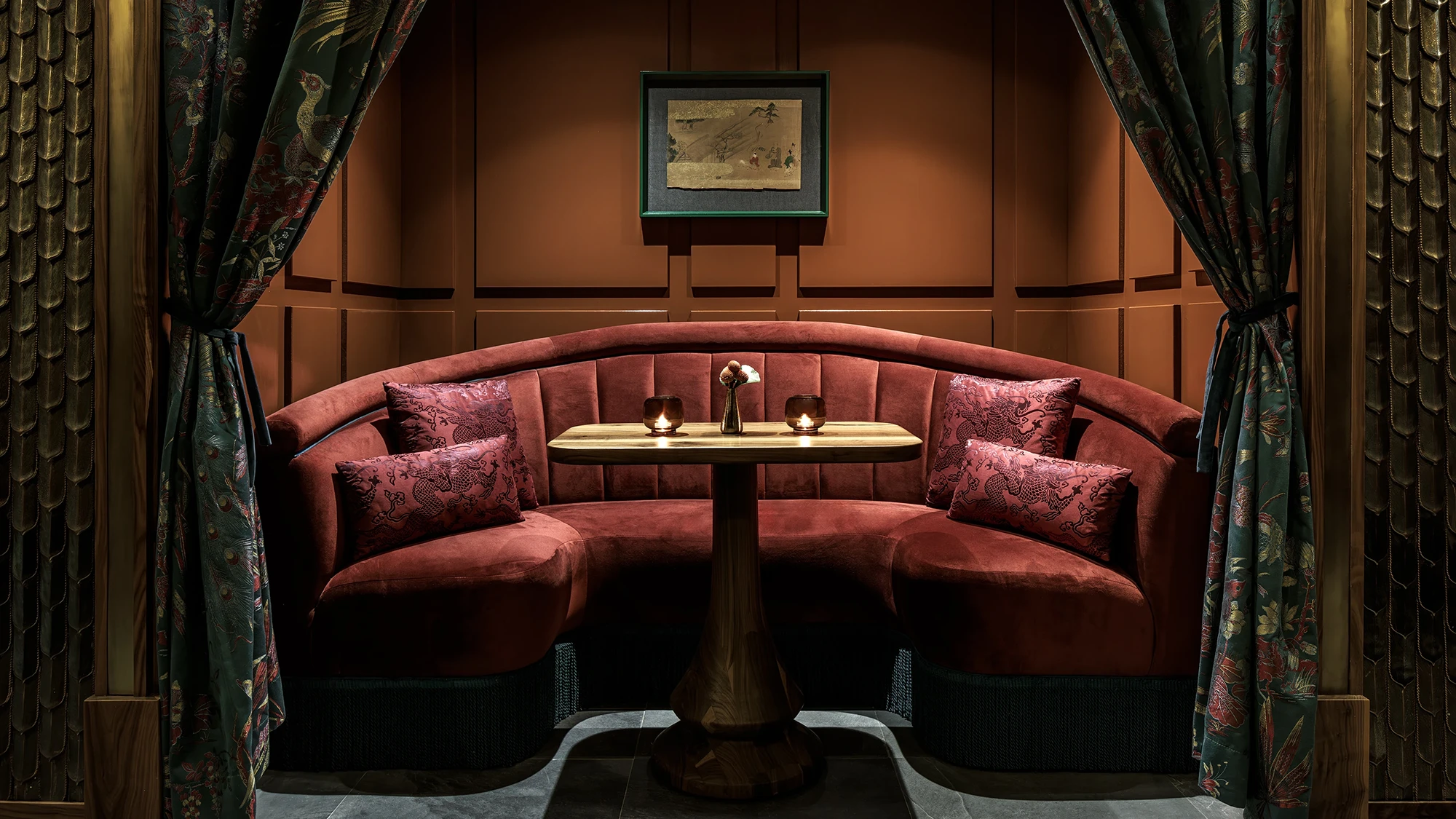 A half-circle booth with red cushions in an indoor lounge area