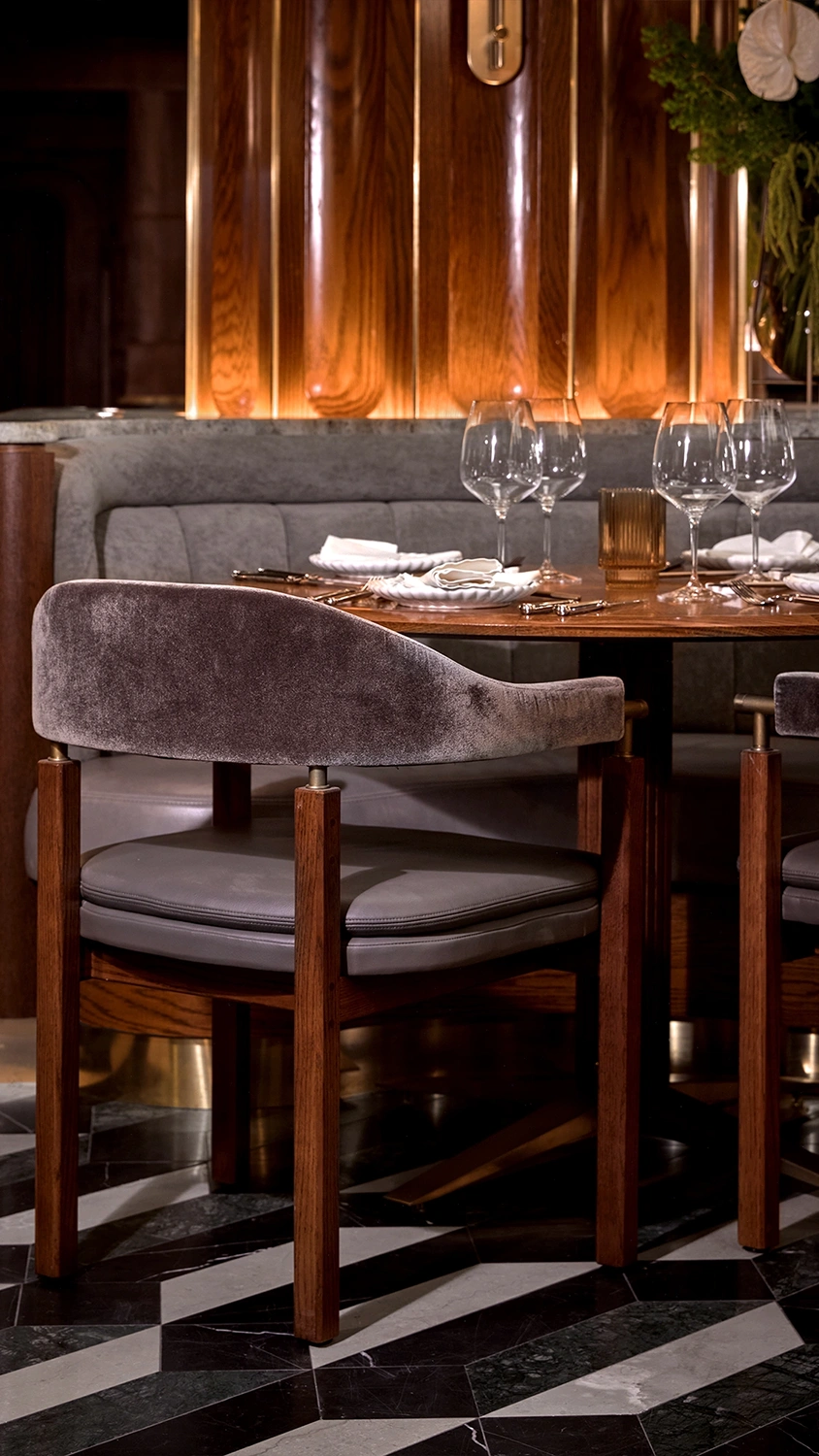 A wooden legged chair upholstered with leather backing and bottoms