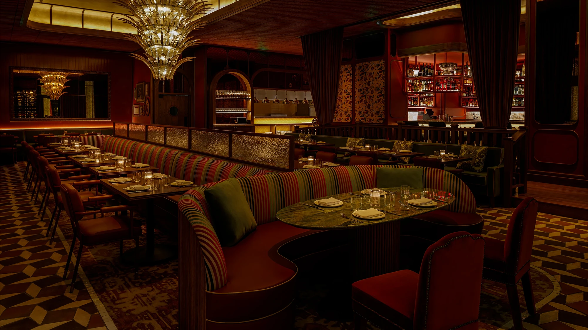 Moody lit Erba Miami restaurant dining room lined with tables and seating set up for guests to enjoy dinner