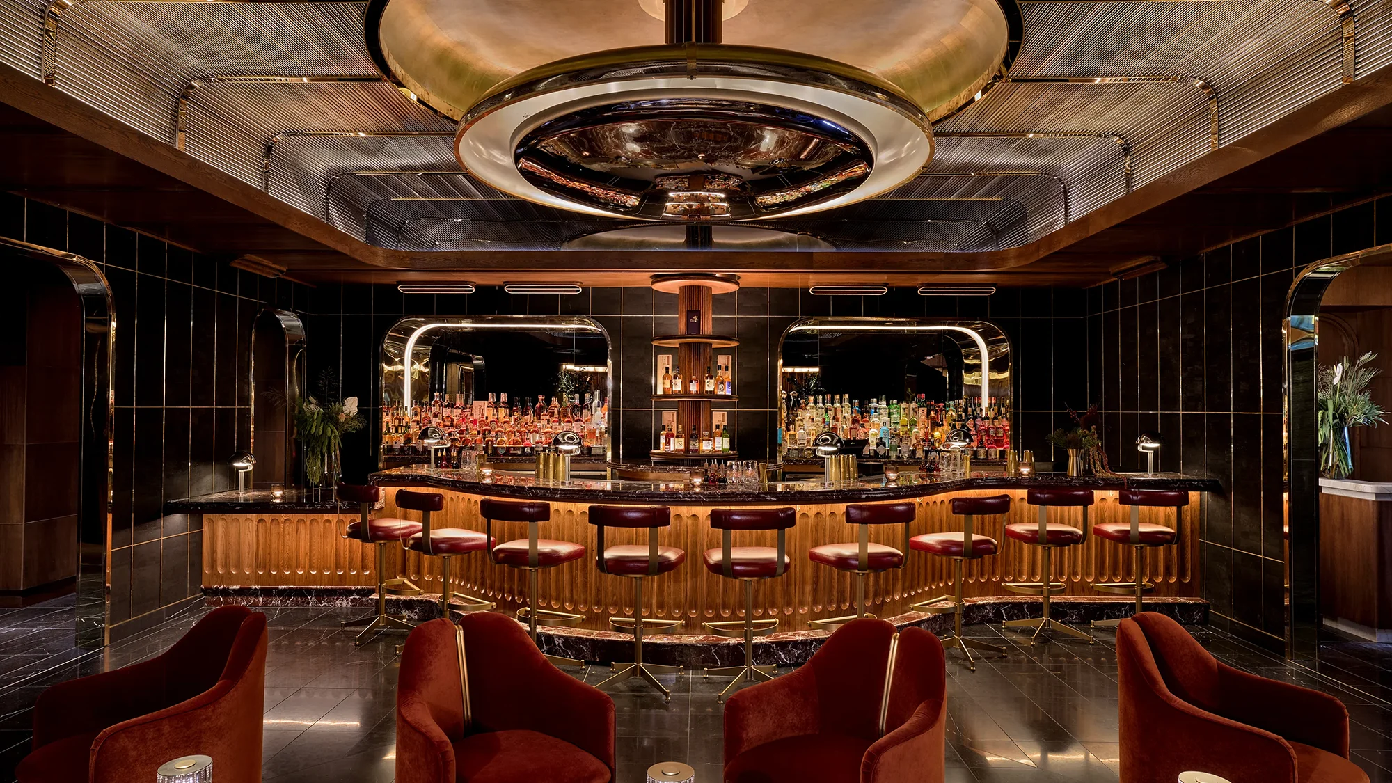 An elegant wooden bar lined with wooden barstools