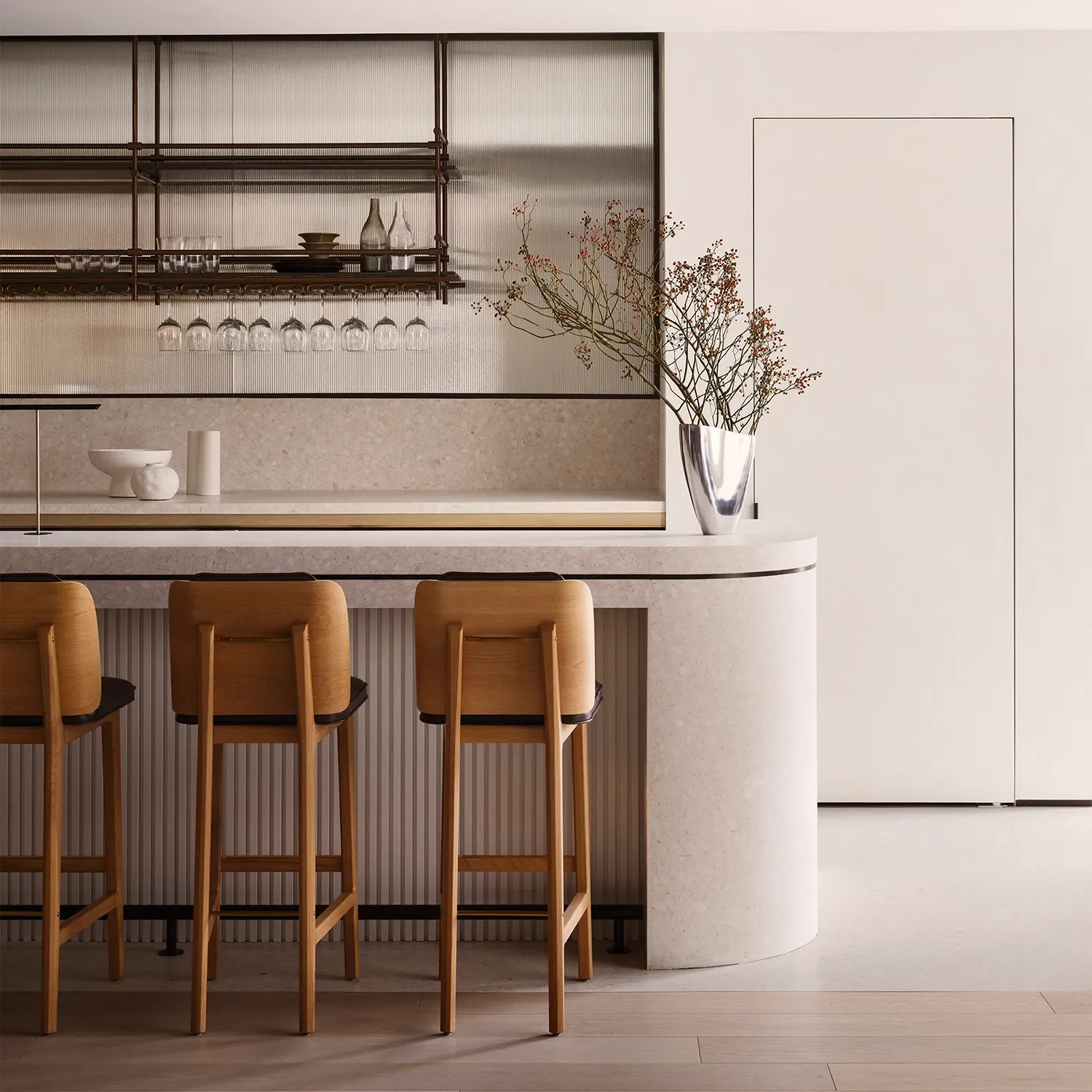 A white bar top lined with wooden high top chairs 